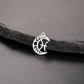 Macro view of silver crescent moon pendant with Pisces zodiac sign on dark rock - Silver-Pisces