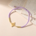 Dettaglio di un bracciale intrecciato viola con ciondolo a quattro foglie dorato - modello 2 / Viola