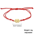 Detail view of golden snowflake charm on red braided rope bracelet with adjustable cord - Snowflake Style-Gold Color