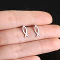 Detailed view of miniature silver fish stud earrings held by hand showing precise scale - Steel