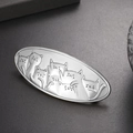 Detailopname van een vintage zilveren haarklem met gedetailleerd reliëf van een kat - Antiek Zilver