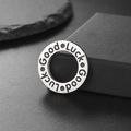 Polished stainless steel Good Luck ring pendant on minimalist dark stone background - Steel