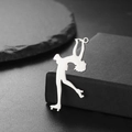 Polished silver roller skating figure pendant resting on a textured dark background - Arabesque Pose (Style 4-Steel)