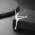 Detailed view of an 18K gold plated roller skater pendant on a textured black stone - Ballet Pose (Style 1-Steel)