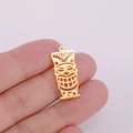 Macro shot of gold-plated hollow Tiki mask pendant held in hand for scale detail - Style 1 Gold