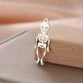 Macro shot of silver hollow skull charm on wooden stand with satin background detail - Style 3 Silver