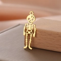 Macro detail of a 18K gold-plated stainless steel hollow skeleton skull pendant charm - Style 5-Gold