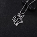 Detailopname van zilveren geometrische wolf hanger op zwarte getextureerde achtergrond - Hondenkop