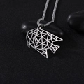 Macro-detail van geometrische zilveren vis-hanger op zwarte stenen met ketting - Goudvis