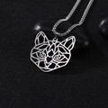Macro-opname van zilveren geometrische kattenhanger met kralenketting op donkere stenen - Kat