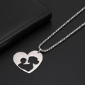 Detail van zilveren hart hanger met moeder en kind silhouet aan een box ketting - Staalkleur