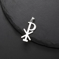 Silberner Edelstahl-Chi-Rho-Anhänger auf dunklem Steinhintergrund für Ketten - Stahlfarbe