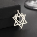 Macro shot of stainless steel hollow heart hexagram pendant on black textured jewelry box - Steel