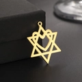 Polished gold cutout hexagram and heart pendant leaning on a dark jewelry box - Gold