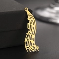 Vue macro du pendentif note de musique en acier inoxydable doré 18K aux lignes épurées - Style Partitions Musicales / Or