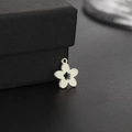 Vue macro d'un pendentif fleur à cinq pétales en acier sur un coffret à bijoux noir - Forme de Fleur (Style 1)