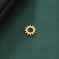 Detaillierte Nahaufnahme eines goldenen hohlen Sonnenanhängers auf dunklem Hintergrund - Sonnenstrahlenform - Gold