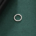 Nahaufnahme des polierten Edelstahl-Rundanhängers mit reflektierender Silberoberfläche - Minimalistischer Ring - Stahlfarbe