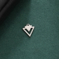 Detail eines silbernen hohlen Dreiecksanhängers aus Edelstahl für DIY-Schmuckherstellung - Geometrischer Hohler Pfeil - Stahlfarbe