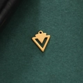 Makrodetail eines geometrischen Doppel-Dreieck-Anhängers aus poliertem Gold-Edelstahl - Geometrischer Hohler Pfeil - Gold