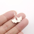 Polished stainless steel ginkgo leaf pendants on fingertips showing natural size and detail - Gingko Leaf Shape - Steel Color