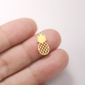 Close-up of a mini gold pineapple pendant with hollow mesh design on a fingertip - Pineapple Shape - Gold