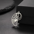 Pendentif coquillage en acier inoxydable poli avec design évidé sur fond noir élégant - Acier