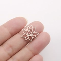 Close-up of polished stainless steel hollow lotus charm held for size reference - Lotus Shape - Steel Color