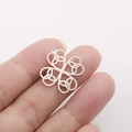 Macro detail of silver Celtic knot clover pendant held between fingers showing its size - Celtic Knot Clover - Steel Color
