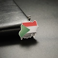 Macro detail of Sudan map charm with enamel flag colors and 18K gold plated stainless steel - Steel