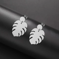 Polished silver monstera leaf drop earrings in stainless steel on black display - Steel