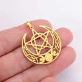 Macro detail of gold stainless steel triple moon pentagram pendant in hand - Gold