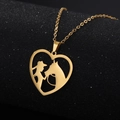 Dettaglio macro del ciondolo a cuore dorato con sagoma di donna e cavallo traforata - Oro