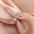 Macro detail of silver chemical molecule ring on soft champagne satin fabric texture - US 7 / Steel