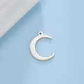 Polished stainless steel crescent moon pendant for DIY jewelry making on blue background - Steel