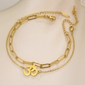 Detailed close-up of golden double-layer chain bracelet featuring an Om symbol pendant - Welding Chain / Gold