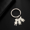 Detail of silver stainless steel keychain featuring three cute cartoon character charms - Boy And Girls / Silver