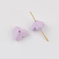 Close-up of matte lavender triangle beads for DIY crafts showing functional center hole - Purple