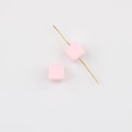 Macro detail of pink acrylic cube beads with straight holes for DIY jewelry crafting - Pink