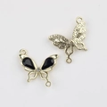 Detailed macro view of a gold-plated butterfly charm with black stones and double link rings - Gold Base Black Rhinestone