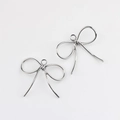 Primer plano de colgantes de lazo de aleación pulida para crear collares y pendientes DIY - Plateado