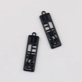 Macro detail of black alloy rectangle charms with cutout Chinese characters for DIY jewelry - Black