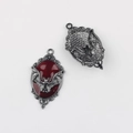 Detalle macro del colgante de murciélago gótico con esmalte rojo y patrones florales de plata - Base Negro de Humo Rojo