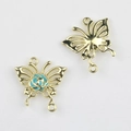 Detalle de dijes de mariposa dorados con rosa azul para la creación de joyas DIY - Base de Oro Azul