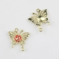 Vista de conectores de mariposa dorados con rosa roja para creación de joyas DIY - Base de Oro Rojo