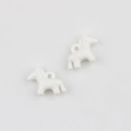 Detail van twee witte ponybedeltjes met gladde afwerking en ophanggaten voor DIY-sieraden - Wit