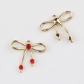 Detalle de colgante de lazo dorado con circonitas rojas para creación de joyas DIY - Dorado / Rojo
