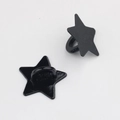 Detail view of black star alloy charms with textured finish and back attachment loop - Black