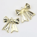 Detalle macro de colgantes de lazo dorado con superficie lisa y anillos de suspensión - Dorado