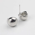 Détail macro de boucles d'oreilles sphériques argentées avec texture martelée et tige S925 - Argent